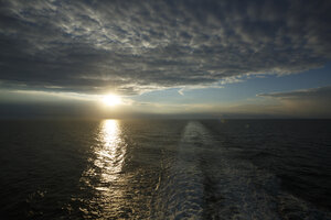 Kalme wateren van de Noordzee weerspiegelen de ondergaande zon