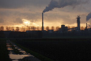Industriecomplex bij zonsondergang, rookpluimen