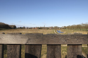 Scenic view of a tranquil landscape with a river, fields, and di