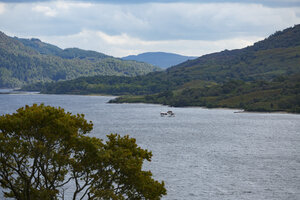 Sereen meer omgeven door groene heuvels