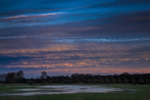Kleurrijke wolken over een veld