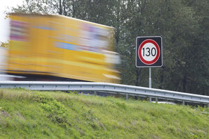 Snelheidslimiet bord langs snelweg met vrachtwagen