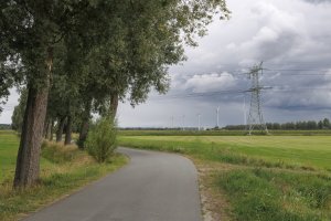 Landelijk pad met windturbines en hoogspanningsmast