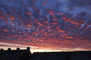 Adembenemende zonsondergang boven huisdaken