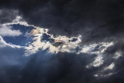 Dramatic sky with dark clouds and a glimpse of sunlight breaking