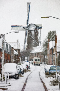 Winterse sneeuw bedekt rustige straat met traditionele windmolen