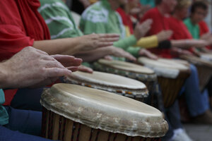 Groep mensen speelt drums op buitenevenement in stadspark