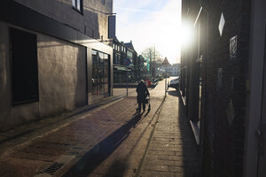 Elderly woman with walker navigating a quiet street in a histori
