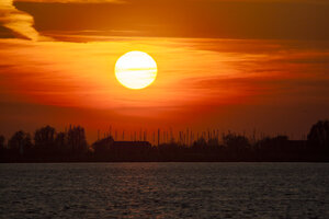 Levendige rode zonsondergang boven brede rivier