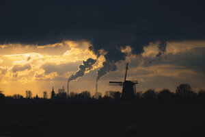 Nederlands novemberlandschap met windmolen en industrie