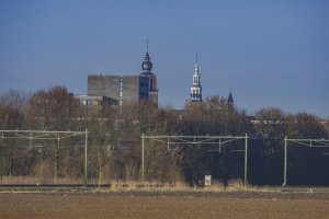 Kerktorens boven landschap bij spoorlijn