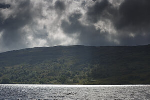 Dramatische wolken boven rustig bergmeer