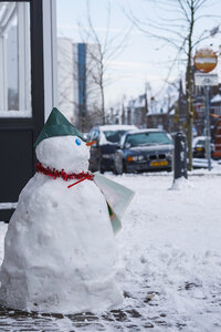 Sneeuwpop met blauwe feesthoed in de sneeuw