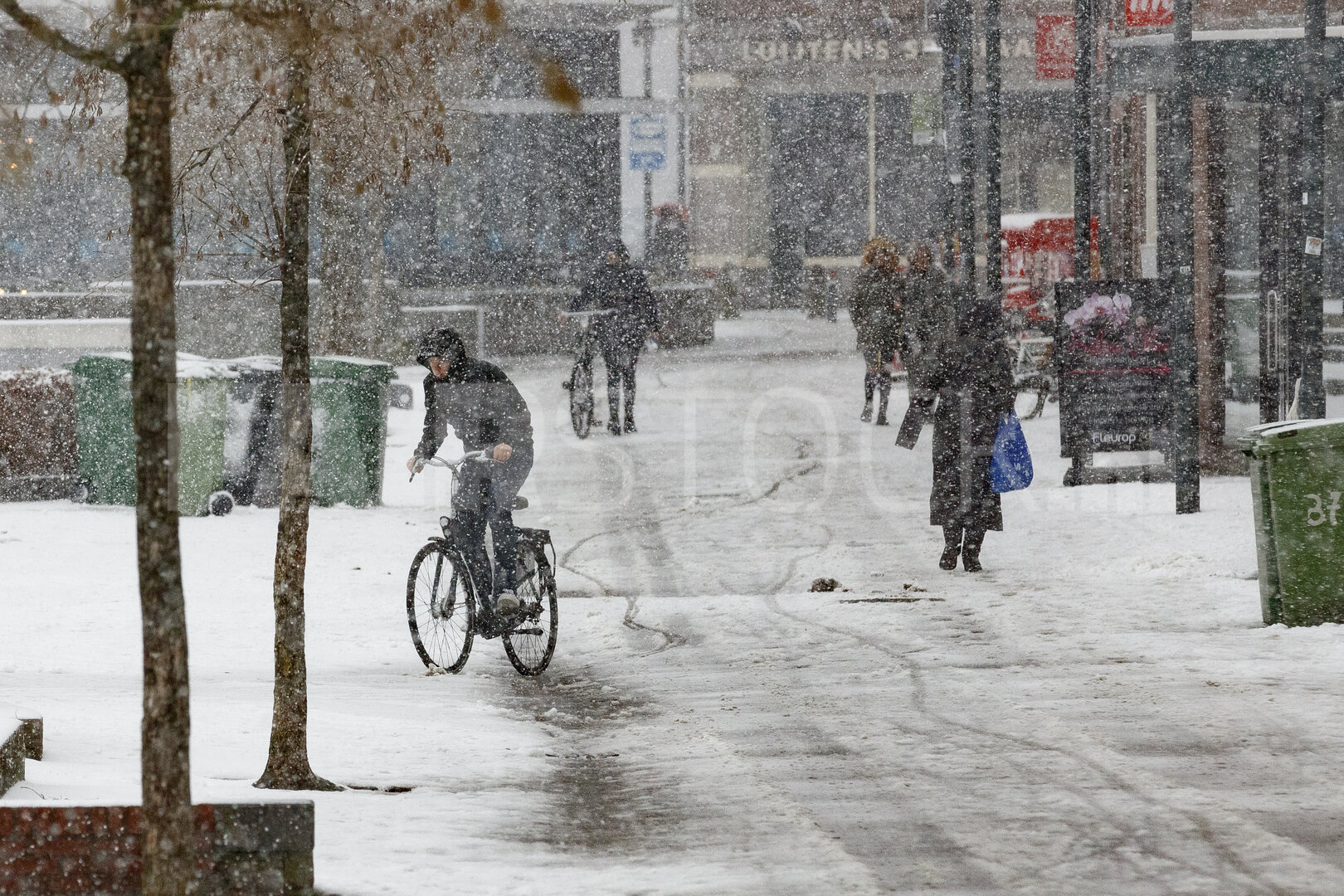 Winterse sneeuwval bedekt stadsstraat met fietsers