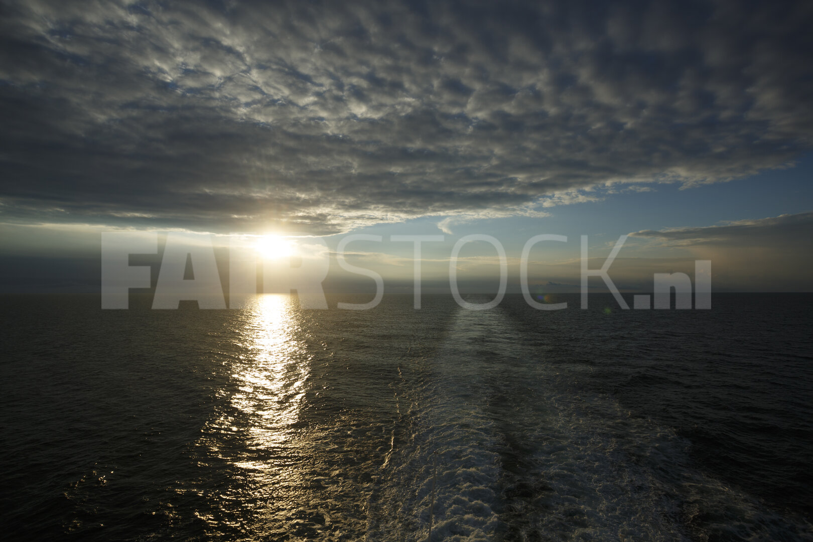 Kalme wateren van de Noordzee weerspiegelen de ondergaande zon