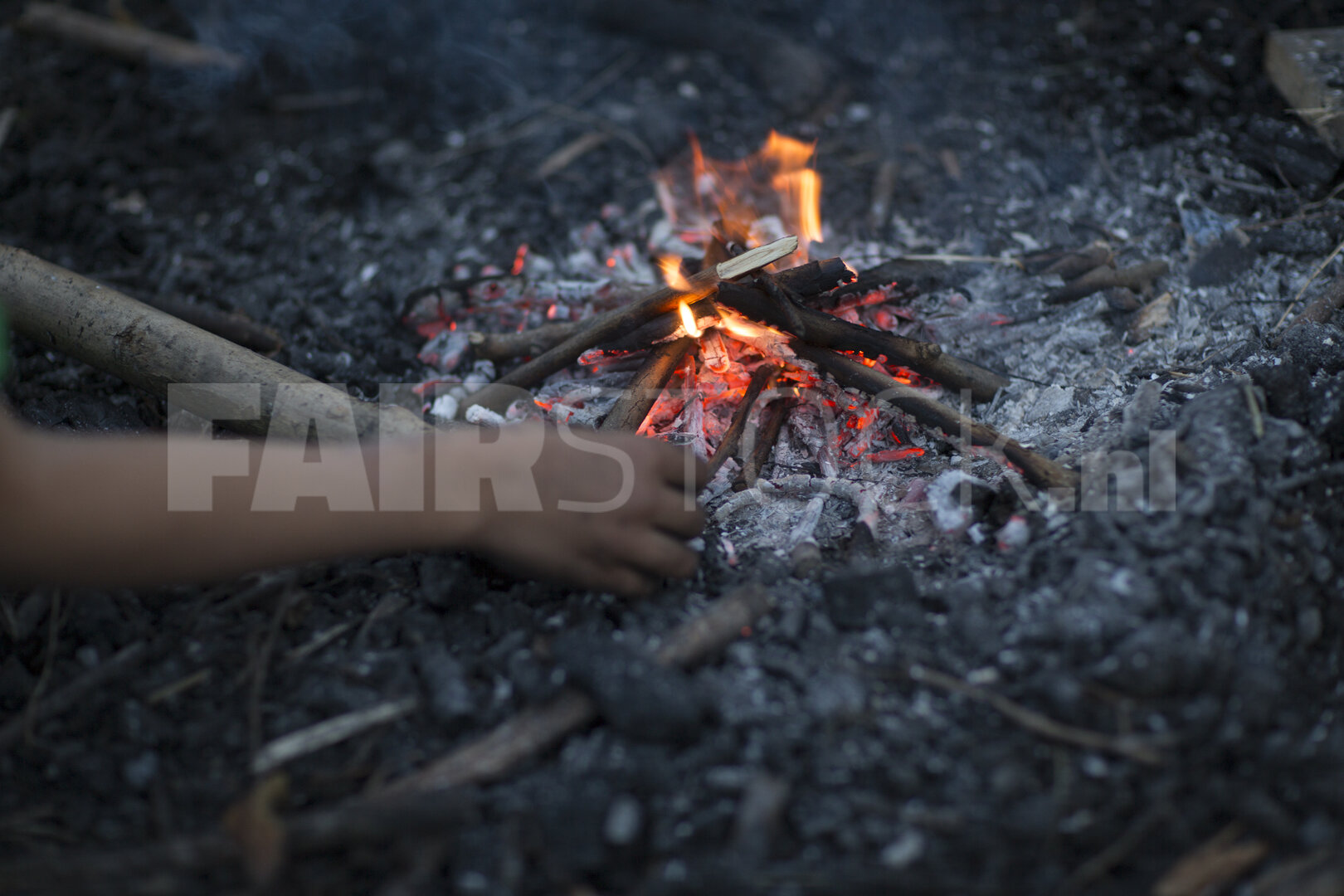 Vuur in de nacht met hand naar de vlam