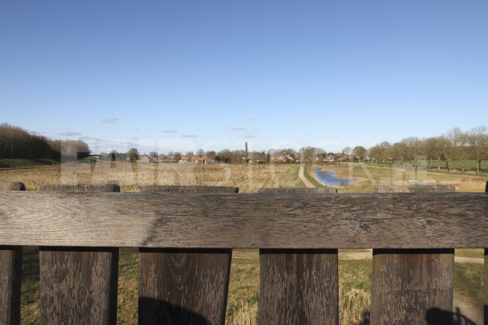 Scenic view of a tranquil landscape with a river, fields, and di