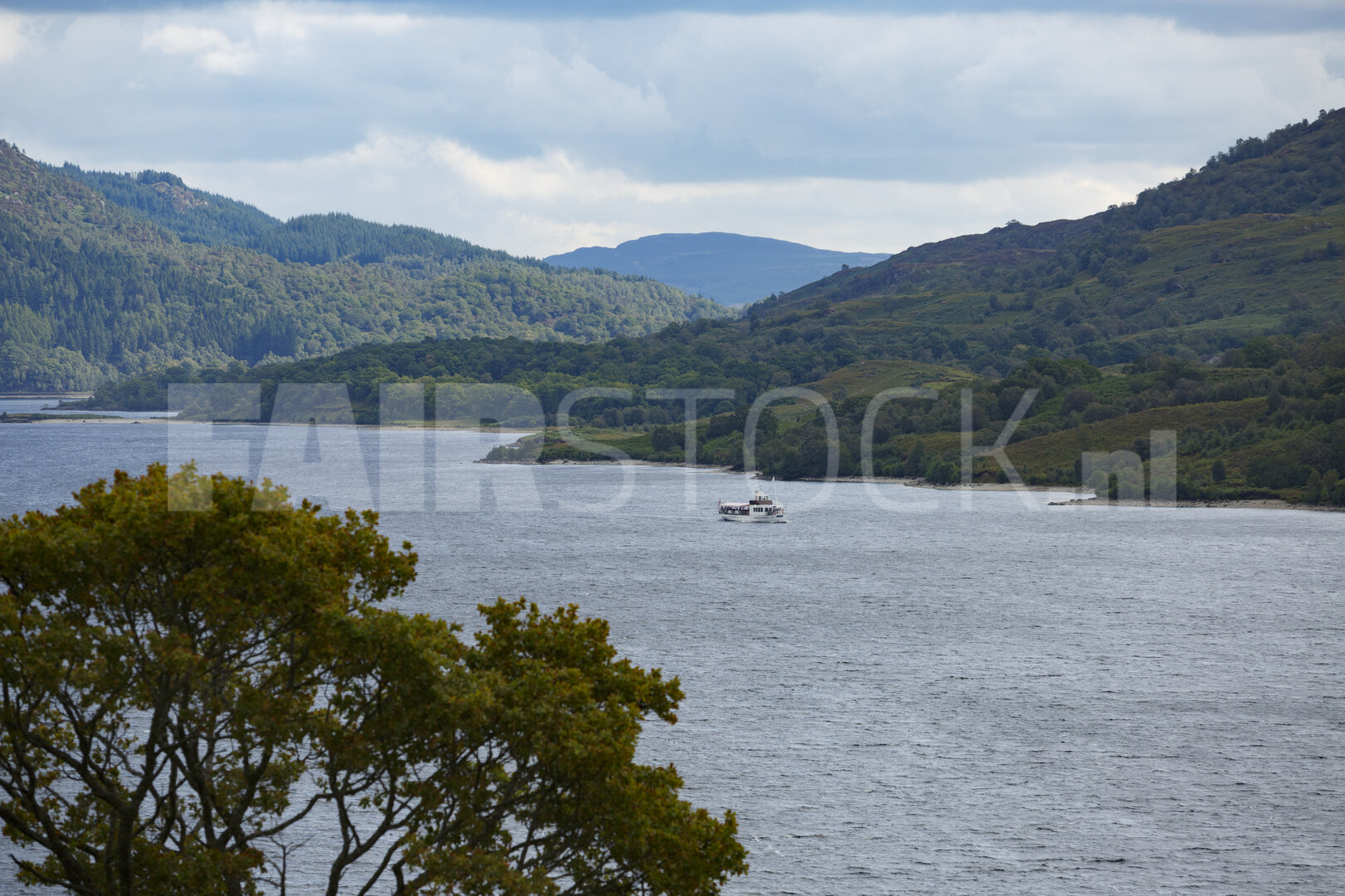 Sereen meer omgeven door groene heuvels