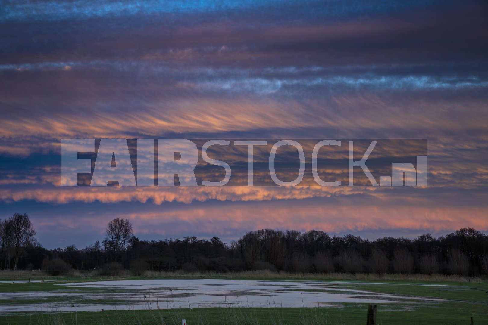 Kleurenpracht bij zonsondergang over waterland