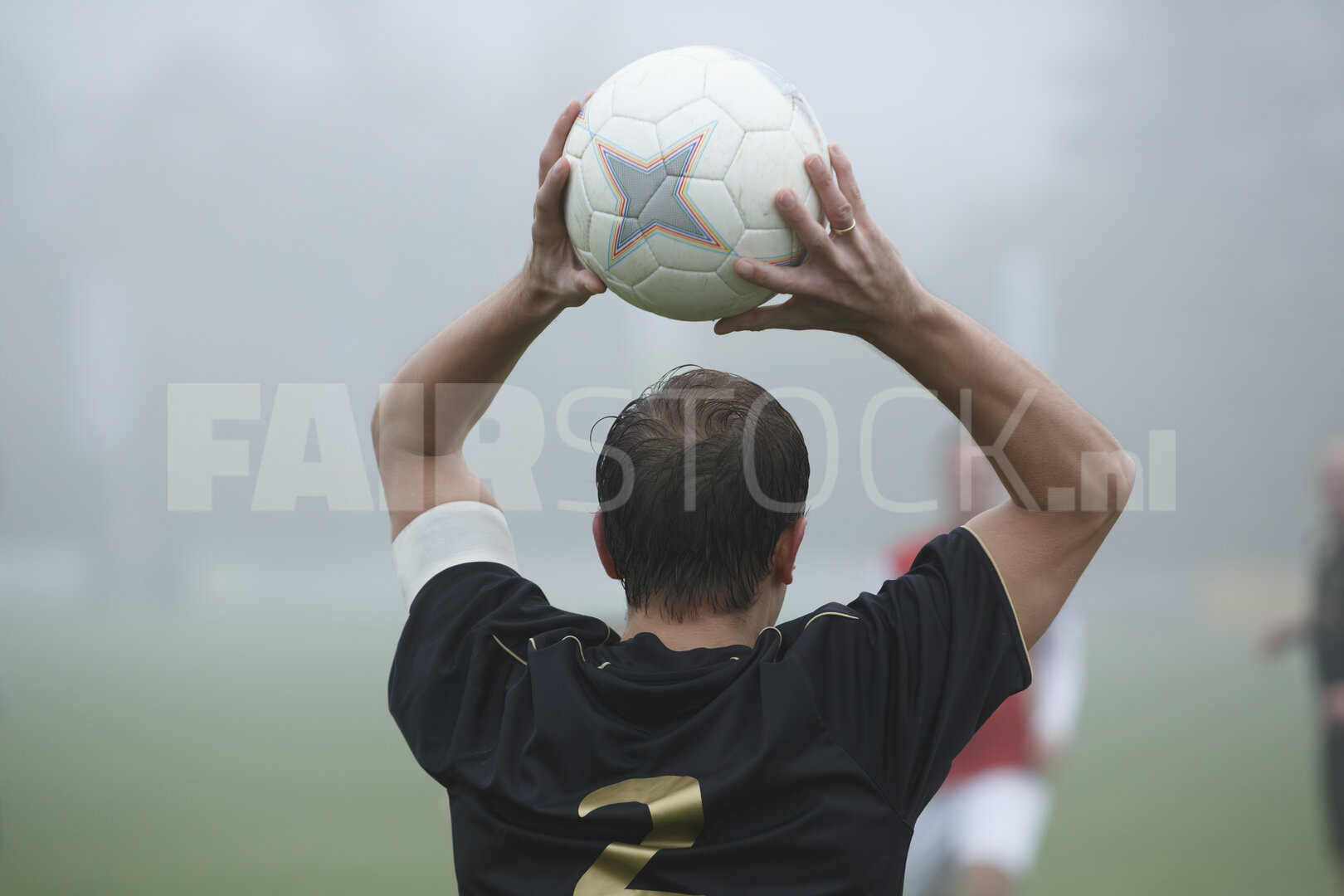 Voetballer bereidt ingooi voor in mist