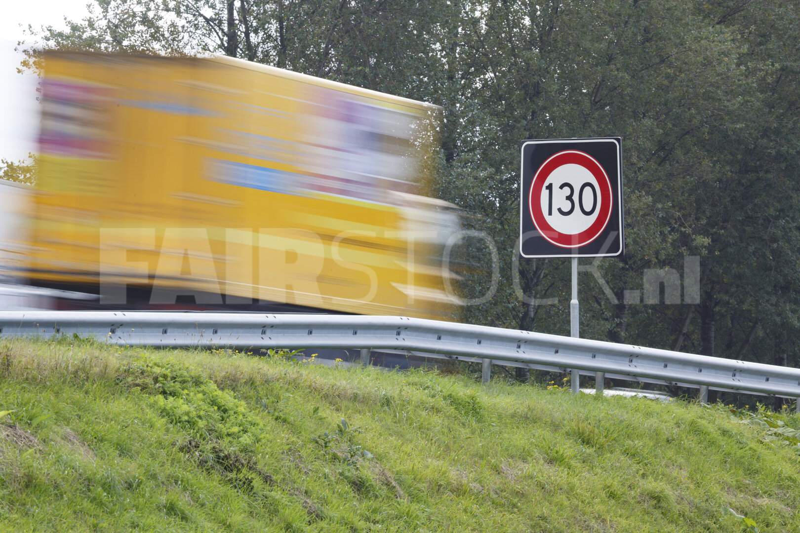 Snelheidslimiet bord langs snelweg met vrachtwagen