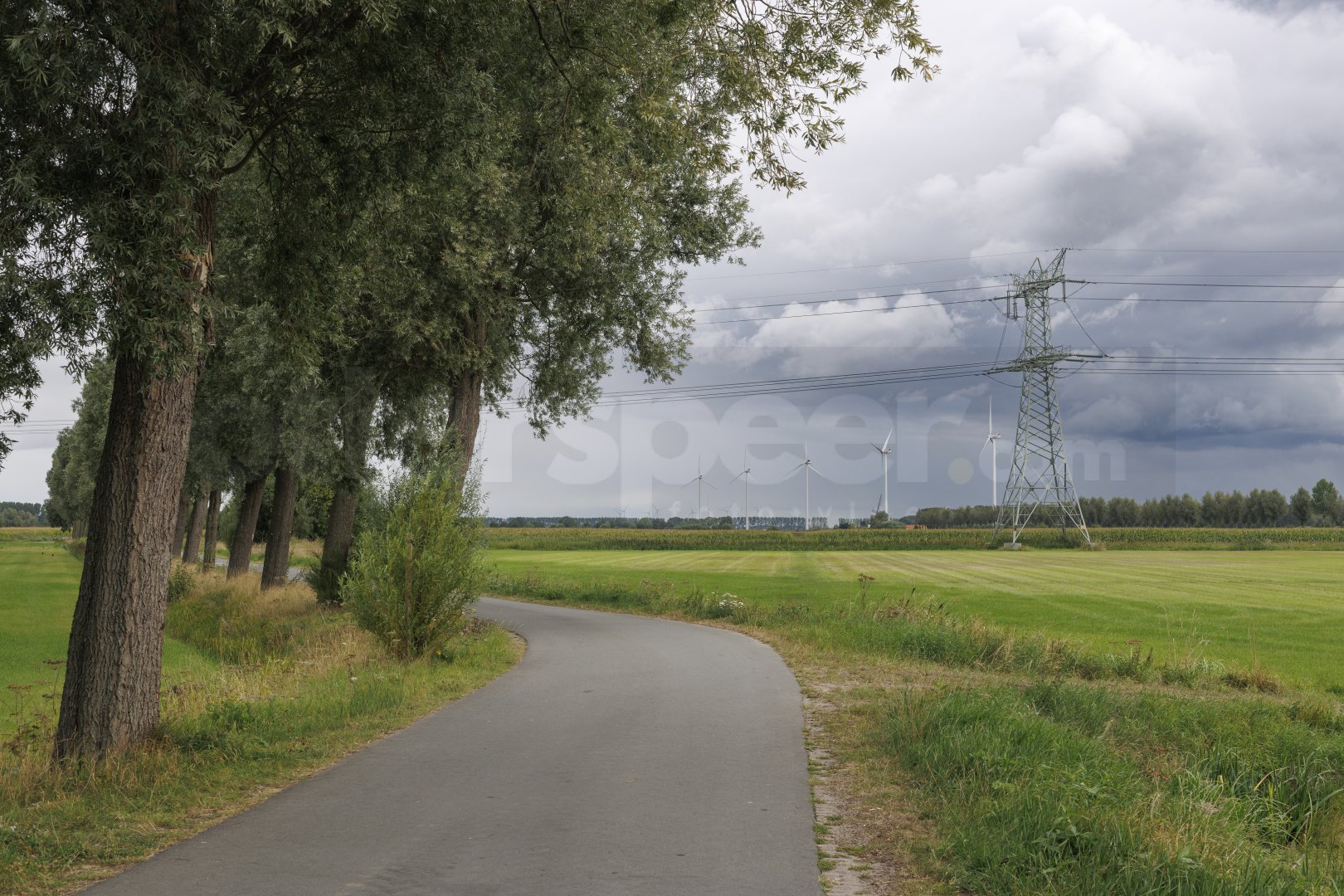Landelijk pad met windturbines en hoogspanningsmast