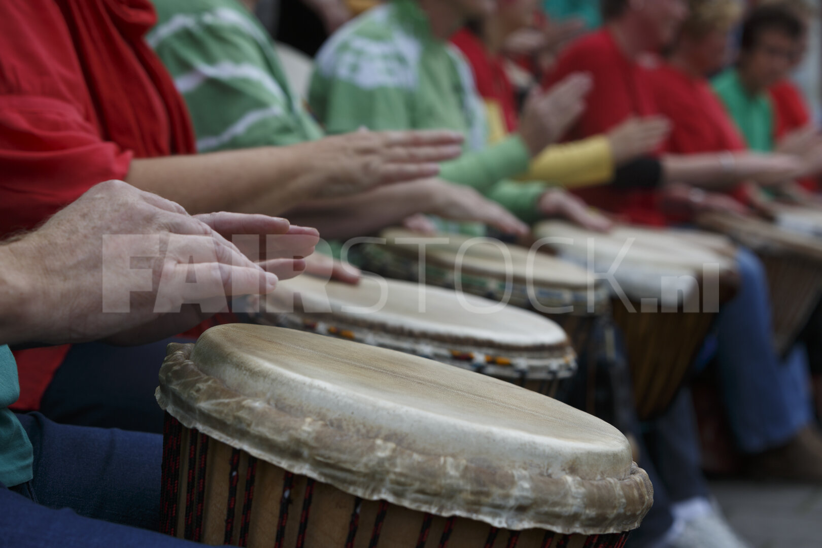 Groep mensen speelt drums op buitenevenement in stadspark