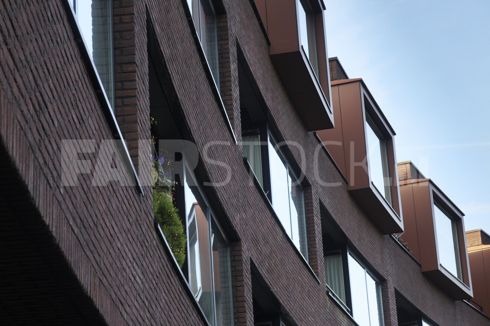 Decorative holiday lights brighten the exterior of an apartment