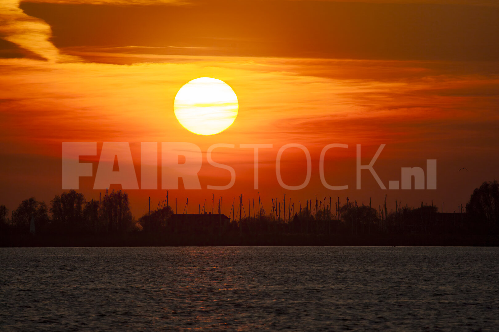 Levendige rode zonsondergang boven brede rivier
