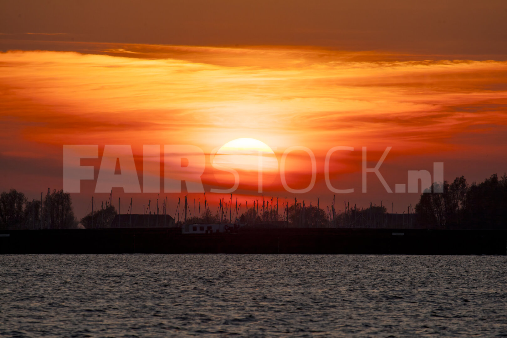 Levendige rode zonsondergang boven brede rivier
