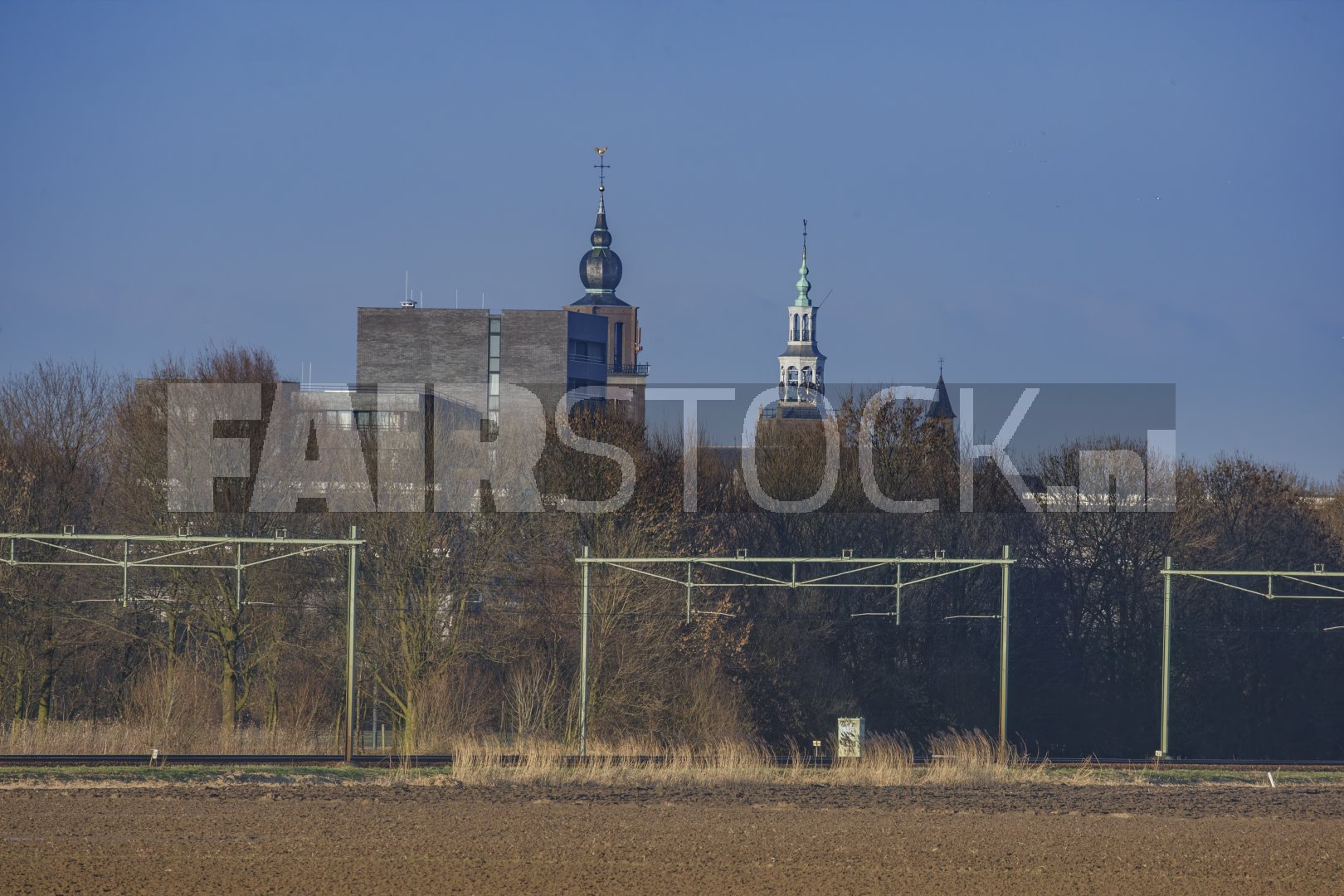 Kerktorens boven landschap bij spoorlijn