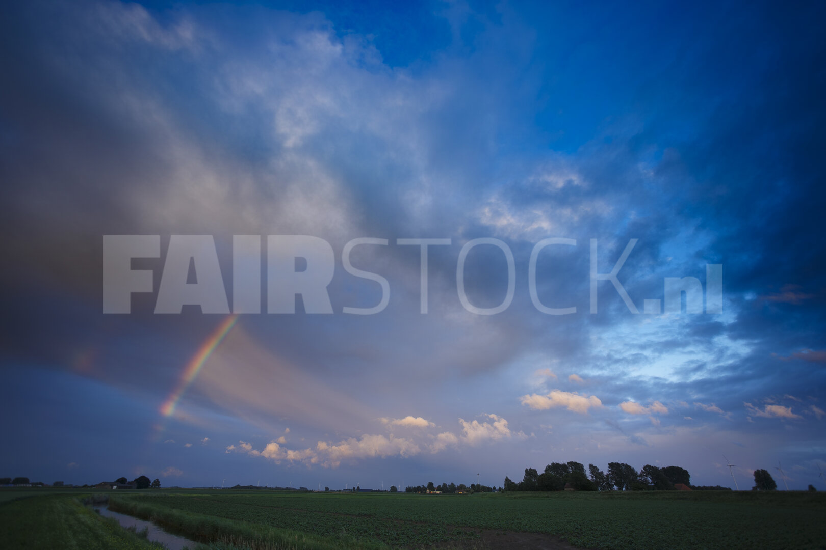 Kleurrijke regenboog boven groene velden
